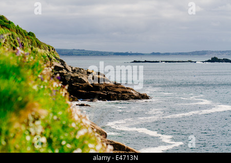 La vista dalla costa sud-ovest percorso sulla costa meridionale della Cornovaglia vicino mousehole, guardando verso la lucertola. mari blu e lussureggiante verde erba Foto Stock