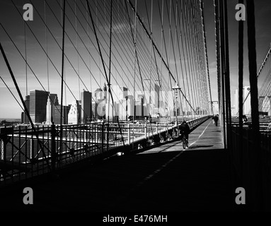 Ciclista sul ponte di Brooklyn e la parte inferiore dello skyline di Manhattan prima dell' 11 settembre 2001 New York City NY USA Foto Stock