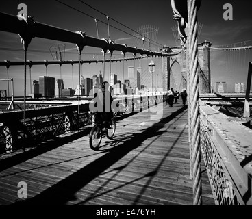 Ciclista sul ponte di Brooklyn e la parte inferiore dello skyline di Manhattan prima dell' 11 settembre 2001 New York City NY USA Foto Stock