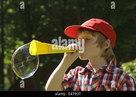 Ritratto di un giovane ragazzo che bolle di sapone Foto Stock