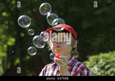 Ritratto di un giovane ragazzo che bolle di sapone Foto Stock