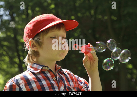 Ritratto di un giovane ragazzo che bolle di sapone Foto Stock