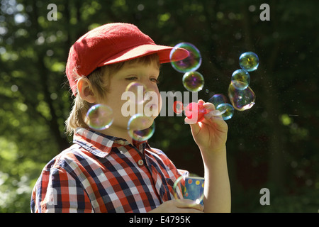 Ritratto di un giovane ragazzo che bolle di sapone Foto Stock