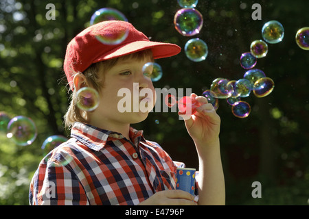 Ritratto di un giovane ragazzo che bolle di sapone Foto Stock