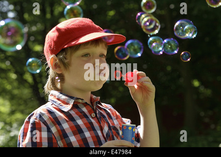 Ritratto di un giovane ragazzo che bolle di sapone Foto Stock