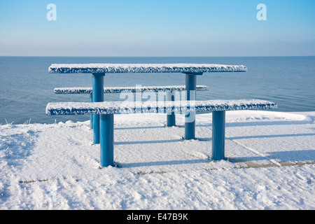 Snowy tavolo da picnic e panca lungo la costa olandese Foto Stock