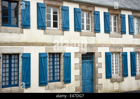 Facciata di tradizionali case bretone con persiane blu, Francia Foto Stock