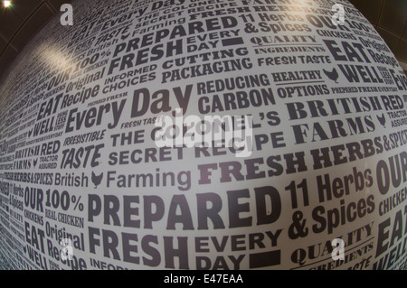 Parete di un KFC uscita con slogan "del colonnello ricetta segreta", "le erbe fresche ", " preparata di fresco" ecc.). Foto Stock