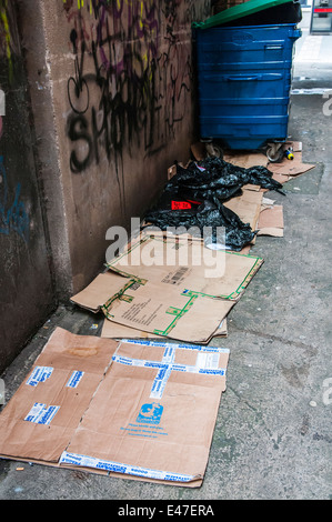 Scatole di cartone sul terreno in un vicolo, utilizzato da persone senza dimora. Foto Stock