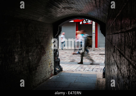 La gente a piedi passato Pottinger ingresso del tunnel in Belfast City Centre. Foto Stock