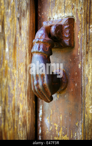 Chiudere su un ferro arrugginito respingente porta in un decaped vecchia porta di legno Foto Stock