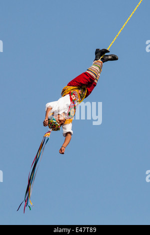 Un sereno 'volador' oscilla intorno al post durante un rituale eseguito in prossimità di Tajin sito di archeologia a Veracruz, Messico. Foto Stock