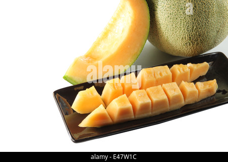 Fette di melone Cantalupo frutto in blackdish su sfondo bianco. Foto Stock