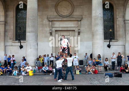 Un esecutore di strada su un monociclo davanti la chiesa di St Paul (comunemente noto come attore' Chiesa) mercato di Covent Garden Foto Stock