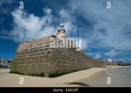 Smeaton è Pier a St Ives in Cornovaglia con la marea fuori rivelando la spiaggia con il blu del cielo e soffici nuvole bianche Foto Stock