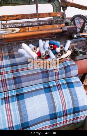 Highland tessuto Tartan e bobine tradizionali sul telaio di tessitura a Lochcarron tessitori in Lochcarron nelle Highlands della Scozia Foto Stock