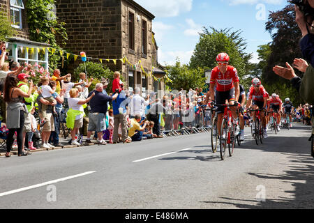 Addingham, Yorkshire. Il 5 luglio 2014. I ciclisti nella prima tappa del Tour de France passano attraverso il villaggio dello Yorkshire di Addingham, con immensa folla festante e sole. Credito: Christina Bollen/Alamy Live News Foto Stock