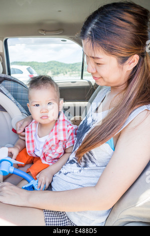 Asian ragazzo seduto in macchina con sua madre, stock photo Foto Stock