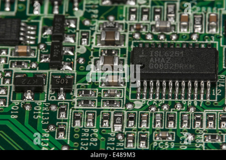 Foto macro della scheda a circuito stampato a montaggio superficiale (SMT) che mostra resistori, condensatori e cablaggio di collegamento, circuito di primo piano. Dettagli di messa a fuoco in "Descrizione" Foto Stock