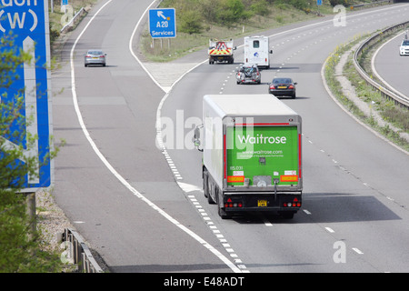 Un Waitrose carrello e altri tipi di traffico che viaggia lungo l'autostrada M20 nel Kent, Inghilterra Foto Stock