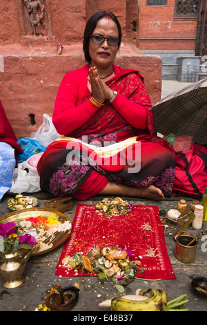 Il Nepal, Kathmandu, Kathesimbhu Stupa,il Tibetano donna in abiti rossi impresa rituale puja buddista Foto Stock