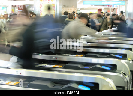 Pendolari stanno precipitando attraverso i tornelli presso la Stazione di Shinjuku la stazione della metropolitana di Tokyo, Giappone. Foto Stock