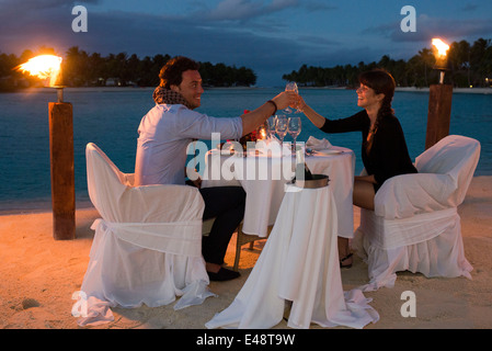 Aitutaki. Isole Cook. Polinesia. Oceano Pacifico del sud. Un giovane gode di una cena romantica in spiaggia in Aitutaki Lagoon Resort Foto Stock