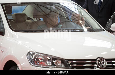 Il cancelliere tedesco Angela Merkel si siede in un pontile VW modello di auto durante la sua visita al FAW-VW Werk, Volkswagen di stabilimento di produzione a Chengdu, in Cina. Il 6 luglio 2014. Angela Merkel è accompagnato con un business di alto livello e di delega rimarrà in Cina fino al 08 luglio 2014. Merkel è anche in programma di visitare Pechino nel corso del suo viaggio. Foto: Kay Nietfeld/dpa Foto Stock