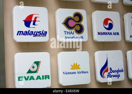 Firma con la compagnia aerea asiatica loghi sono fissati ad una parete in corrispondenza di una agenzia di viaggio in Phnom Penh Cambogia. Foto Stock