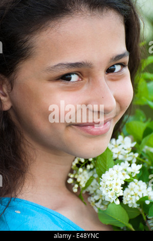 Ragazza donna teen ghirlanda natura primavera cherry ritratto adolescente bella dolce bruna positivo lunghi capelli ricci sorriso scuro uno o Foto Stock