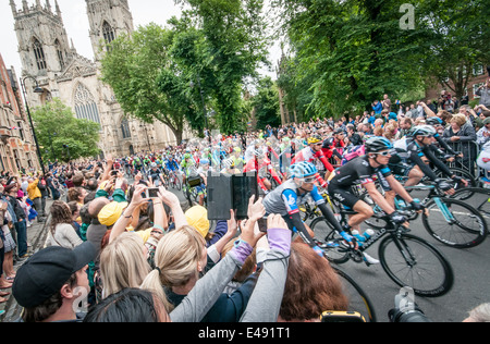 La gente guarda il Tour de France peleton passando York Minster a York Regno Unito Foto Stock