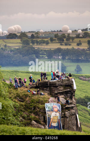 Blubberhouses, North Yorkshire, Regno Unito il 6 luglio 2014. La folla si riuniscono su uno sperone di roccia in 'Kex Gill' per una breve distanza prima del vertice Blubberhouses. Sullo sfondo sono sferiche impianti radar presso la base statunitense a Menwith Hill. Copyright IanWray/Alamy Live news Foto Stock