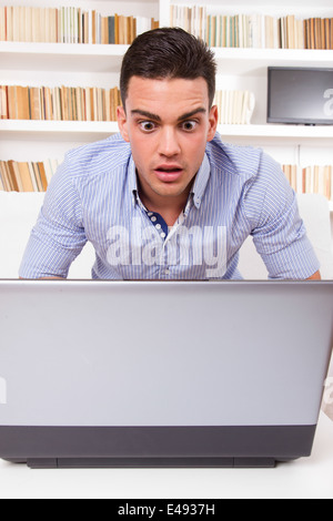 Interessato business man guardando il monitor del computer scioccato Foto Stock