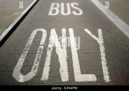 Bus di marcature di corsia sul blocco strada pavimentata superficie. Foto Stock