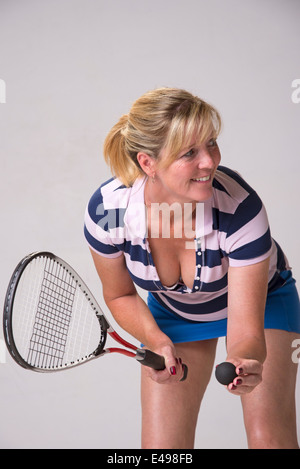 Femmina di giocatore di squash in blu e bianco vestito tenendo palla e racchetta Foto Stock