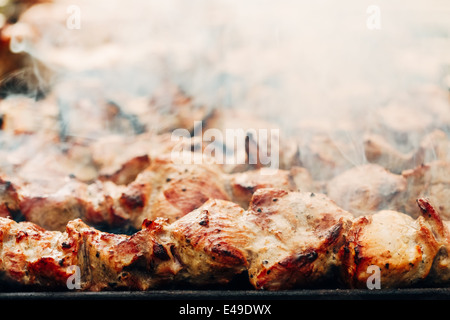 Alla griglia marinati caucaso barbecue spiedini di carne (shish kebab) carne di maiale grigliare su spiedino di metallo, close up Foto Stock