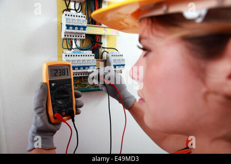 Un elettricista con un multimetro Foto Stock