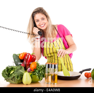 Bella donna di cottura e parlando al telefono Foto Stock