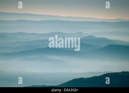 Foschia nelle valli di montagna all'alba Foto Stock