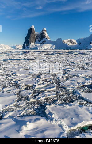 In transito attraverso il canale di Lemaire pesante nel primo anno il mare di ghiaccio in Antartide, regioni polari Foto Stock