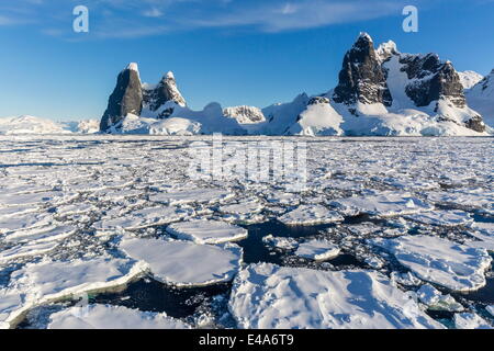 In transito attraverso il canale di Lemaire pesante nel primo anno il mare di ghiaccio in Antartide, regioni polari Foto Stock