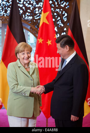 Pechino, Cina. 7 Luglio, 2014. Il cancelliere tedesco Angela Merkel, (L), e il presidente cinese Xi Jinping agitare le mani prima di un incontro presso il Diaoyutai State Guesthouse a Pechino in Cina 07 luglio 2014. Merkel è su una tre giorni di visita in Cina e si prevede di tenere colloqui con funzionari cinesi a rafforzare i legami tra i due paesi. Foto: KAY NIETFELD/dpa/Alamy Live News Foto Stock