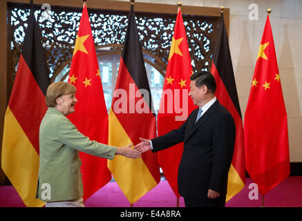 Pechino, Cina. 7 Luglio, 2014. Il cancelliere tedesco Angela Merkel, (L), e il presidente cinese Xi Jinping agitare le mani prima di un incontro presso il Diaoyutai State Guesthouse a Pechino in Cina 07 luglio 2014. Merkel è su una tre giorni di visita in Cina e si prevede di tenere colloqui con funzionari cinesi a rafforzare i legami tra i due paesi. Foto: KAY NIETFELD/dpa/Alamy Live News Foto Stock