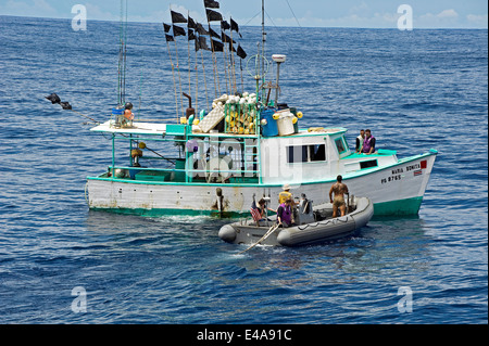 I marinai a bordo della USS Ingraham in un Rigid-Hulled barca gonfiabile rig una barca da pesca per il traino dopo il sequestro 793 chilogrammi di cocaina contrabbandati a bordo della barca Giugno 04, 2014 al largo della Costa Rica. Foto Stock