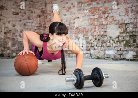 Donna con barbells facendo esercizio di fitness in una palestra Foto Stock