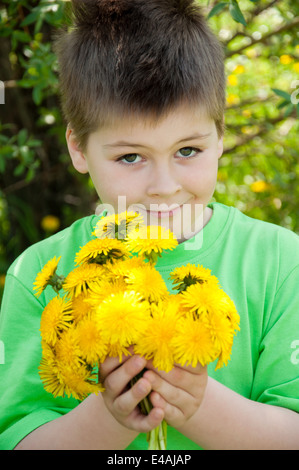 Bambino ritratto una splendida bionda di tarassaco giorno estivo soleggiato 8 otto anni resto appoggio giallo molti clearing prato prato g Foto Stock