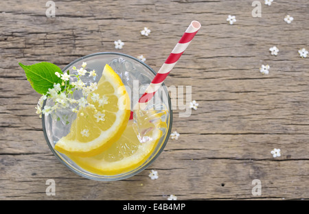 Fiori di sambuco aromatizzati estate cocktail di ristoro con spicchi di limone sul vecchio tavolo in legno, visto dal di sopra Foto Stock