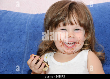 La bambina mangia una torta Foto Stock