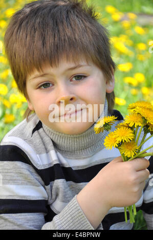 Un ragazzo con un bouquet di tarassaco Foto Stock