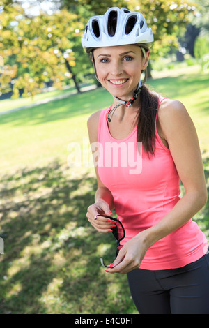 Ciclismo donna prendendo una pausa nel parco Foto Stock